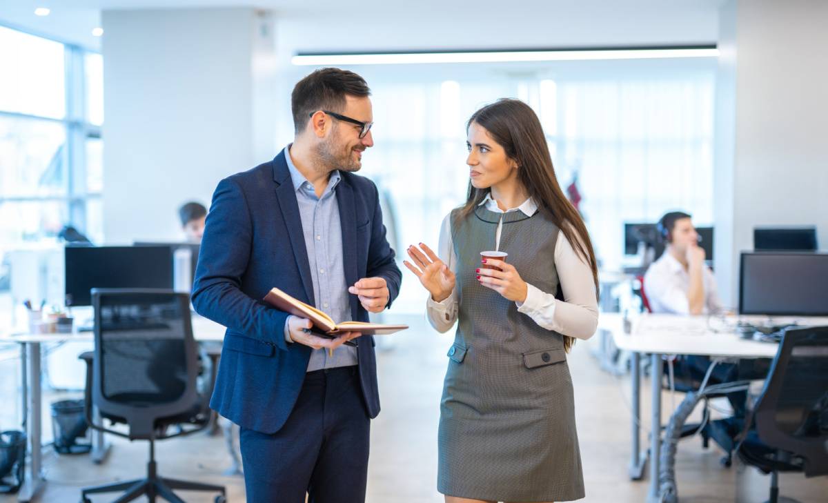オフィスを歩きながら話す男女