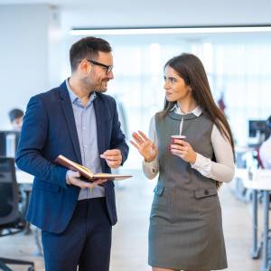  オフィスを歩きながら話す男女 