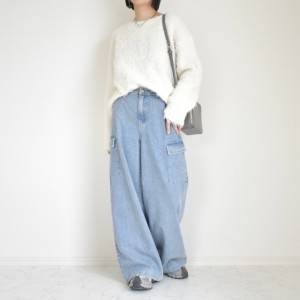  白トップスにデニムパンツを合わせた女性 