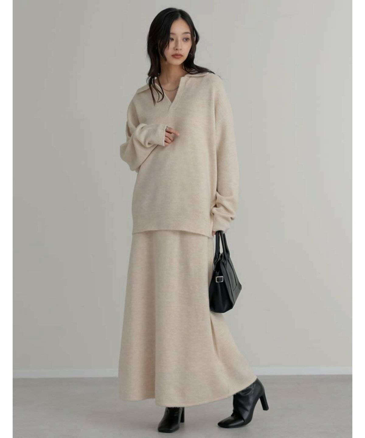 白のニットセットアップを着た女性