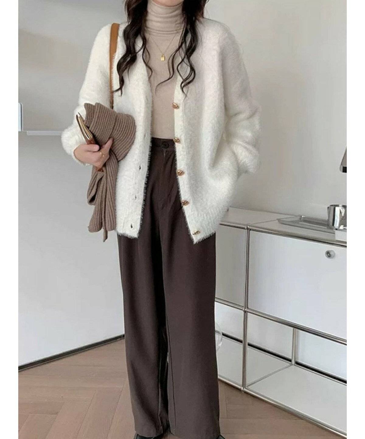 白ニットに白カーディガンを合わせてパンツを穿いた女性
