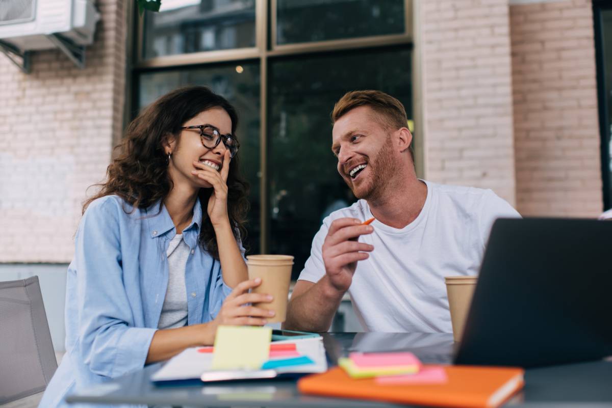 屋外のテーブルで話し合う男女