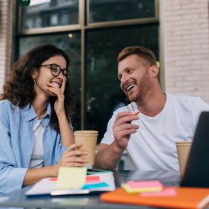  屋外のテーブルで話し合う男女 