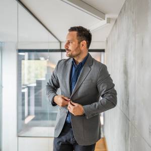  ジャケットのボタンを閉める男性 