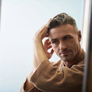  鏡を見ながら髪の毛を整える男性 