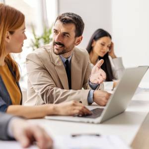  パソコンを見ながら話す男女 