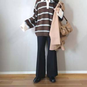  ブラウンのトップスに黒パンツを合わせた女性 