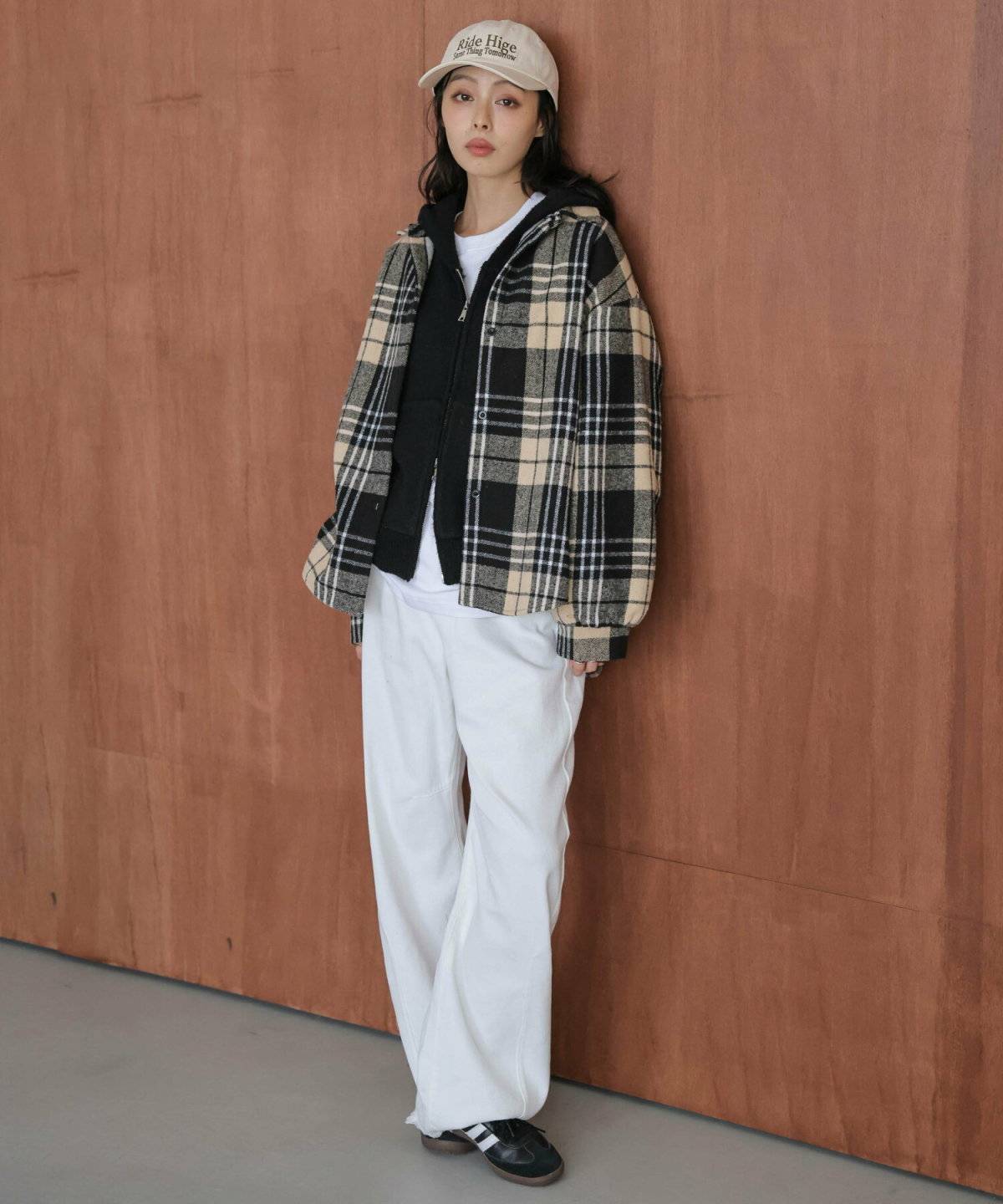 チェック柄シャツに白パンツを合わせた女性