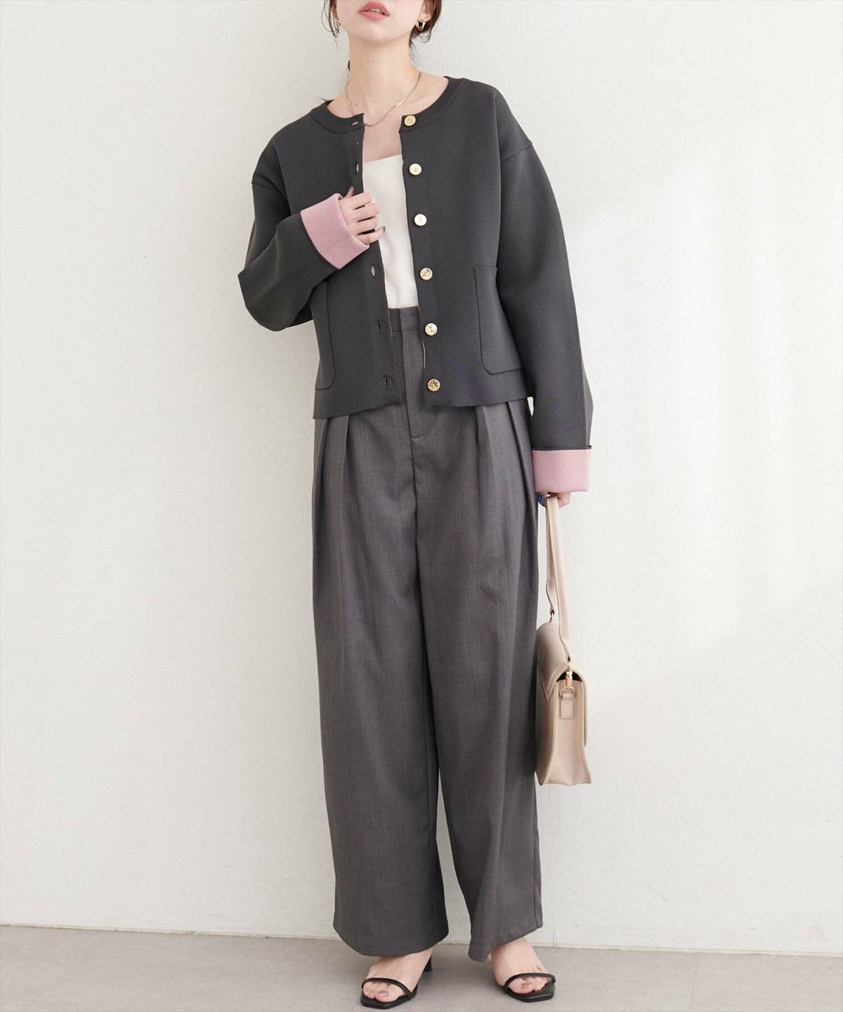 黒カーディガンにグレーのパンツを合わせた女性