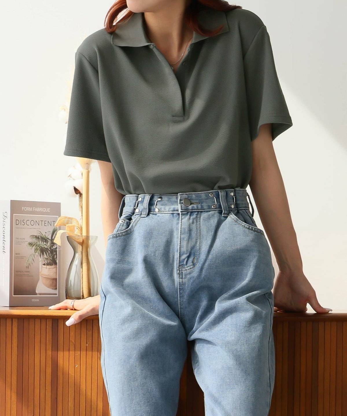 黒のポロシャツにデニムを合わせた女性