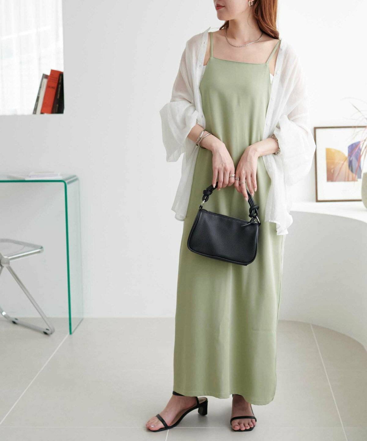 シャツにグリーンのワンピースを合わせた女性