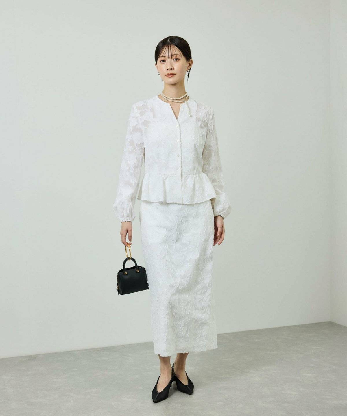 オールホワイトコーデの女性