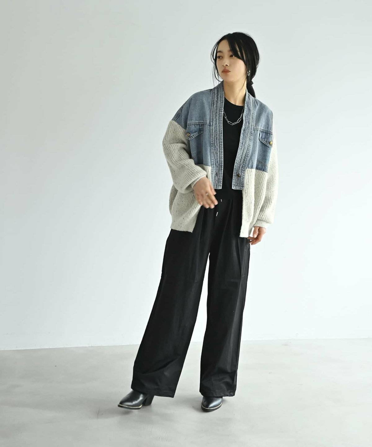 黒のセットアップにデニムジャケットを羽織った女性