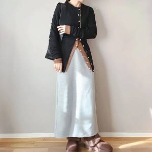  黒カーディガンにグレースカートを合わせた女性 