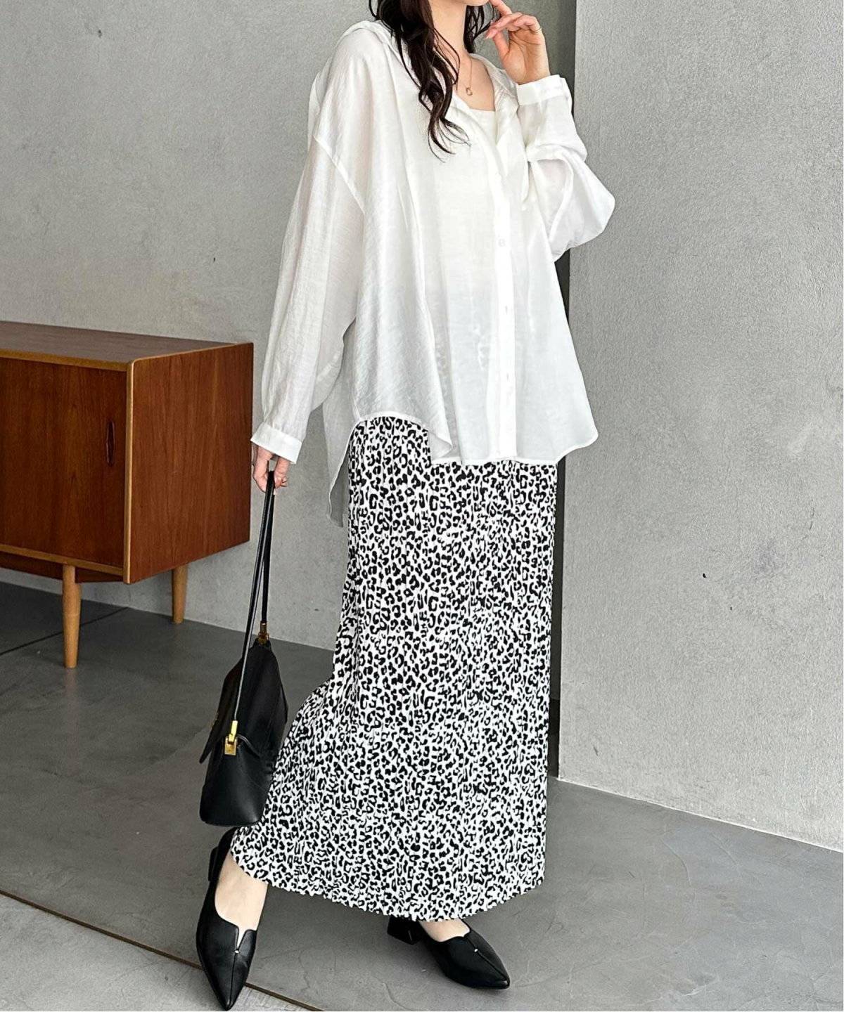 白シャツに柄のスカートを合わせた女性