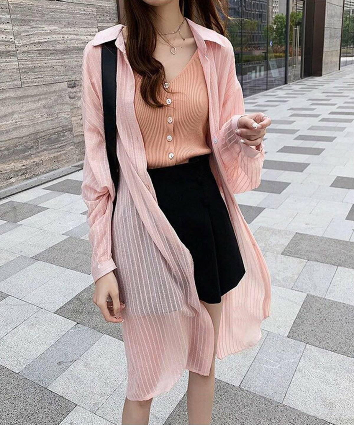 ピンクのシャツに黒のショートパンツを合わせた女性