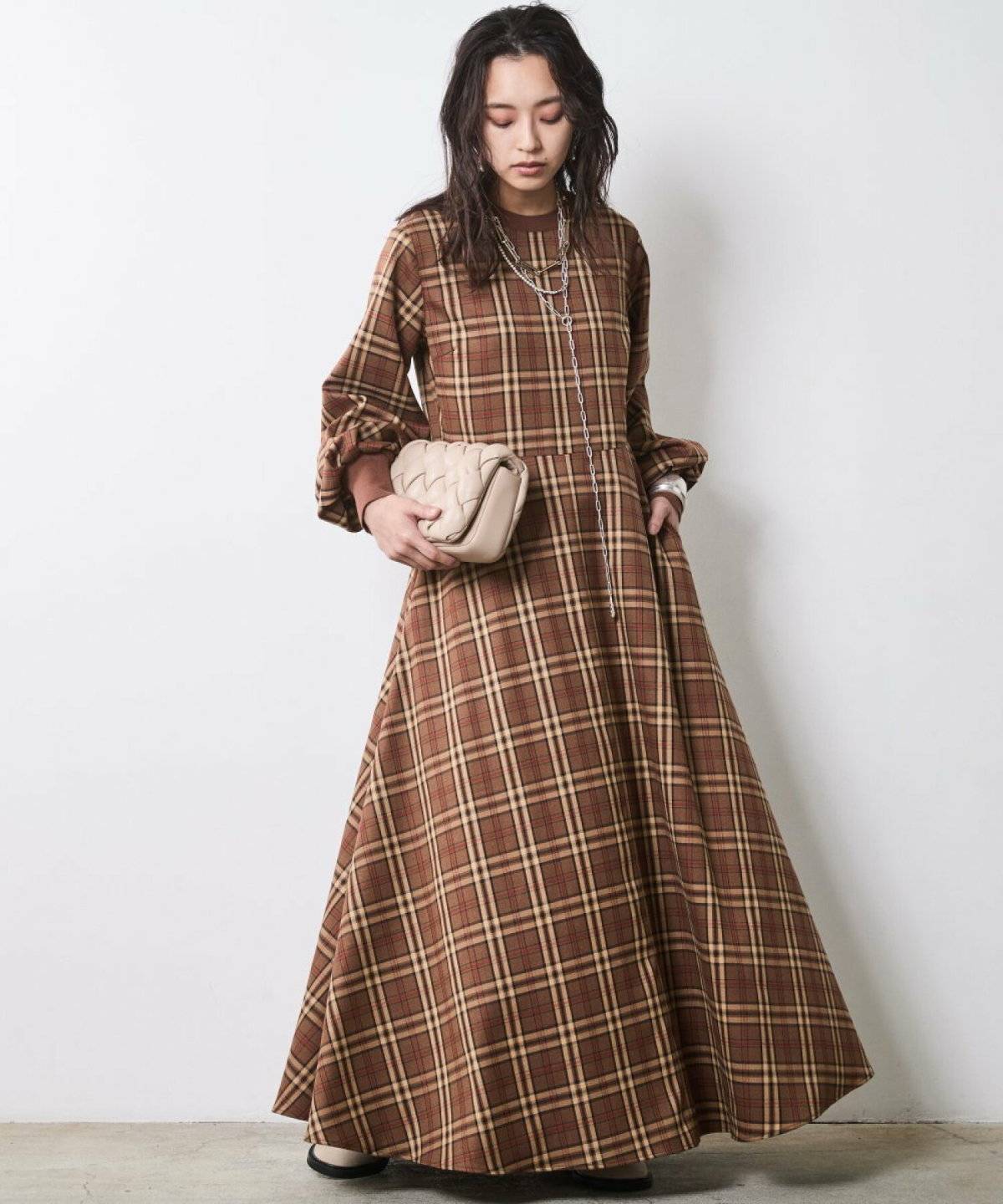 ブラウンのチェック柄ワンピースを着た女性