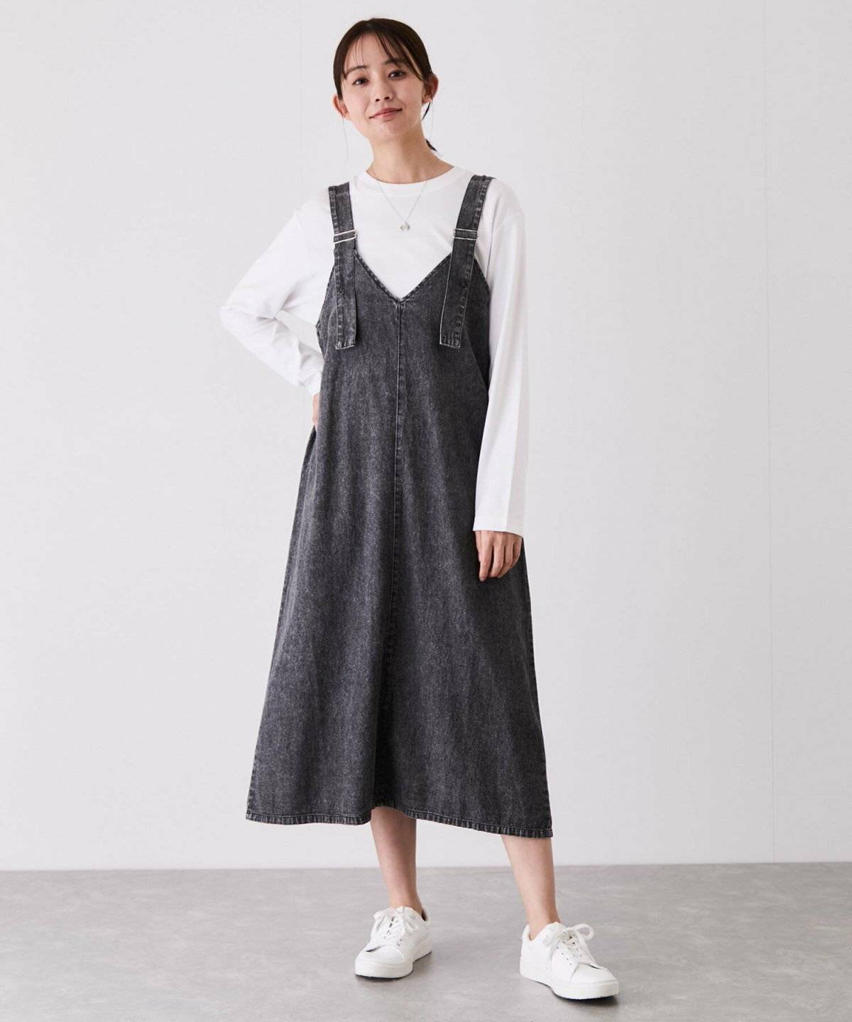 白トップスにジャンパースカートを合わせた女性