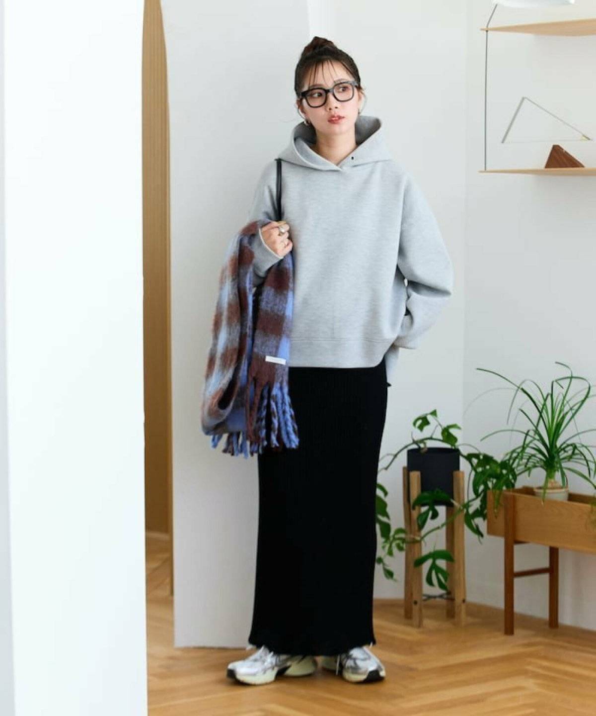 グレーのパーカーにスカートを合わせた女性