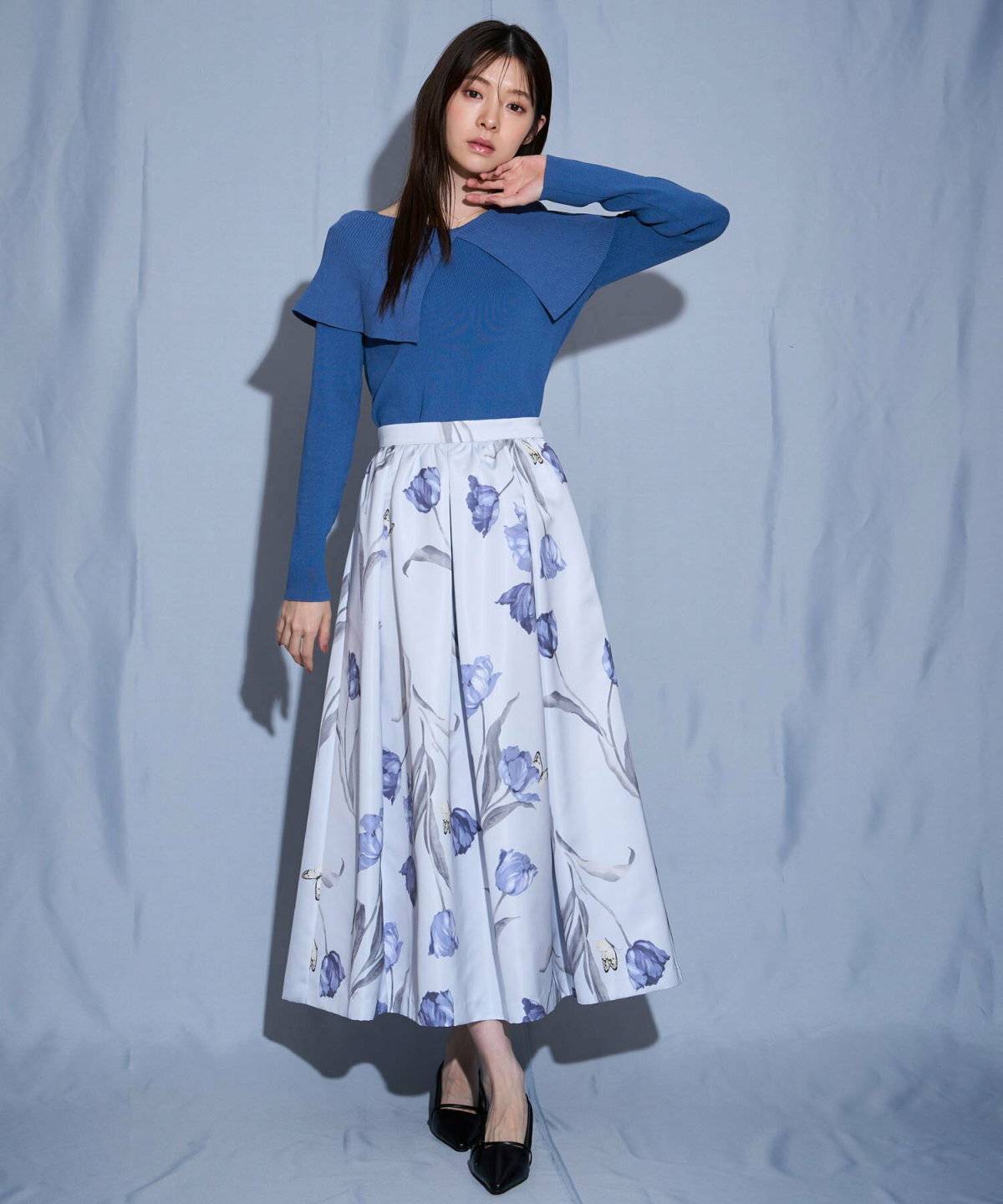 パープルのニットにスカートを合わせた女性