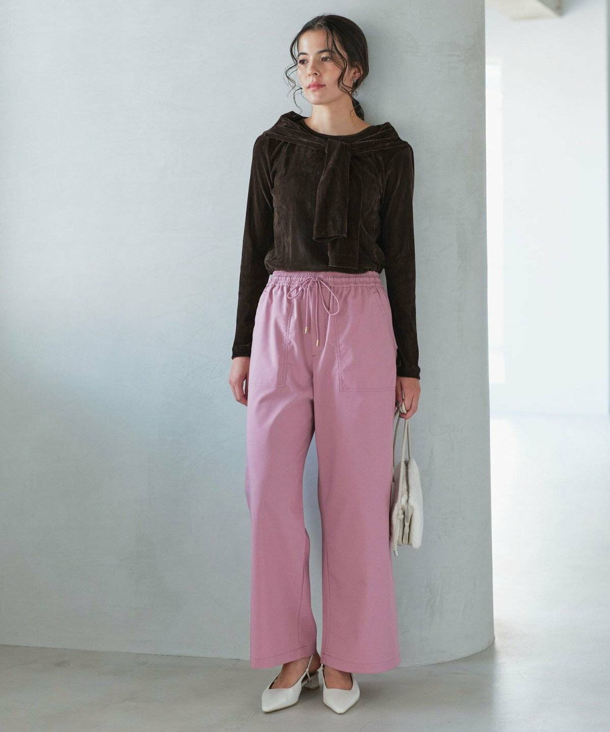 ニットアンサンブルにパンツを合わせた女性