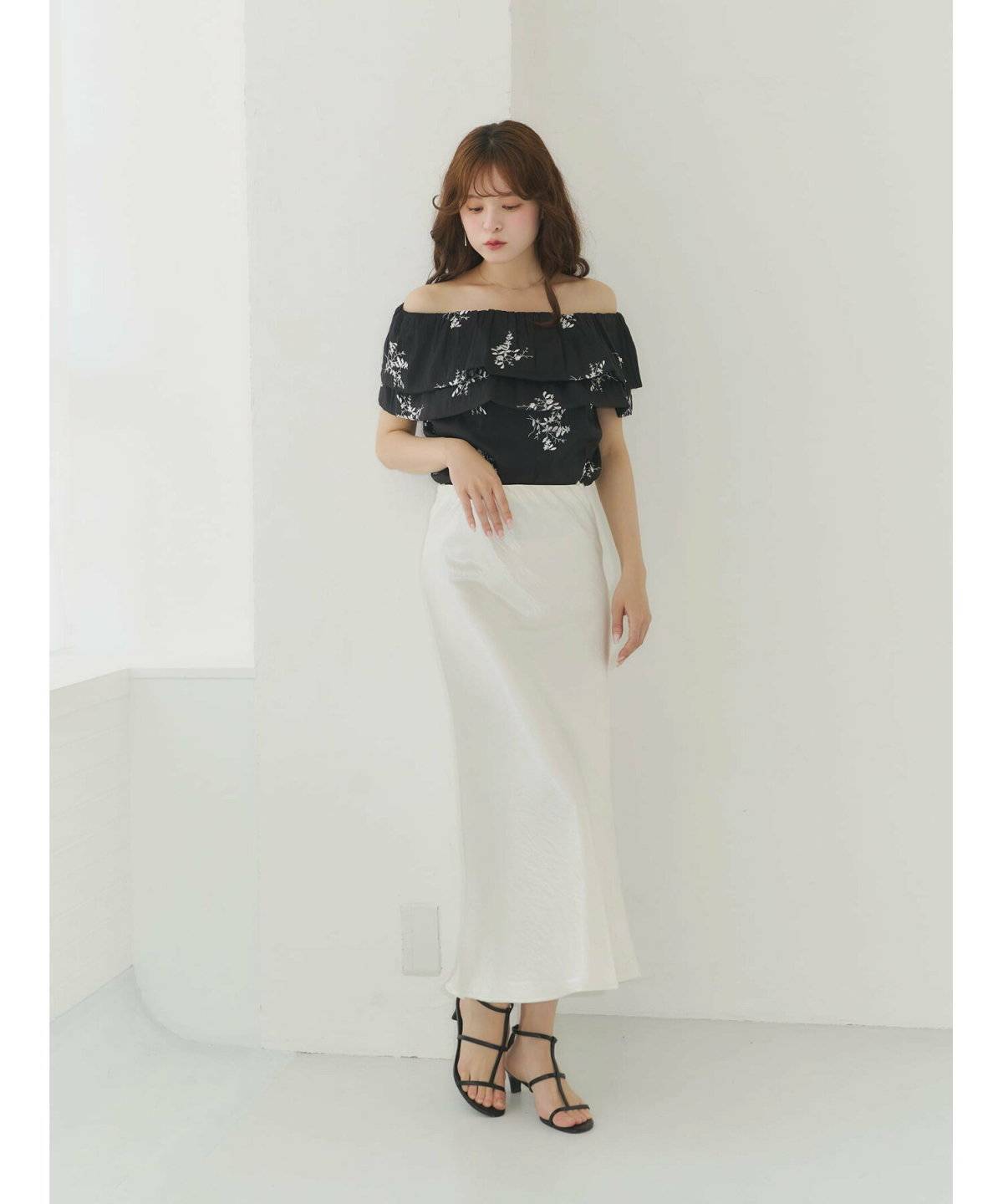 花柄ブラウスにホワイトスカートを合わせた女性