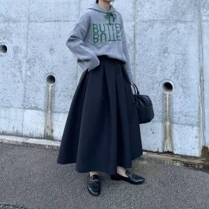  グレーのパーカーに黒スカートを合わせた女性 