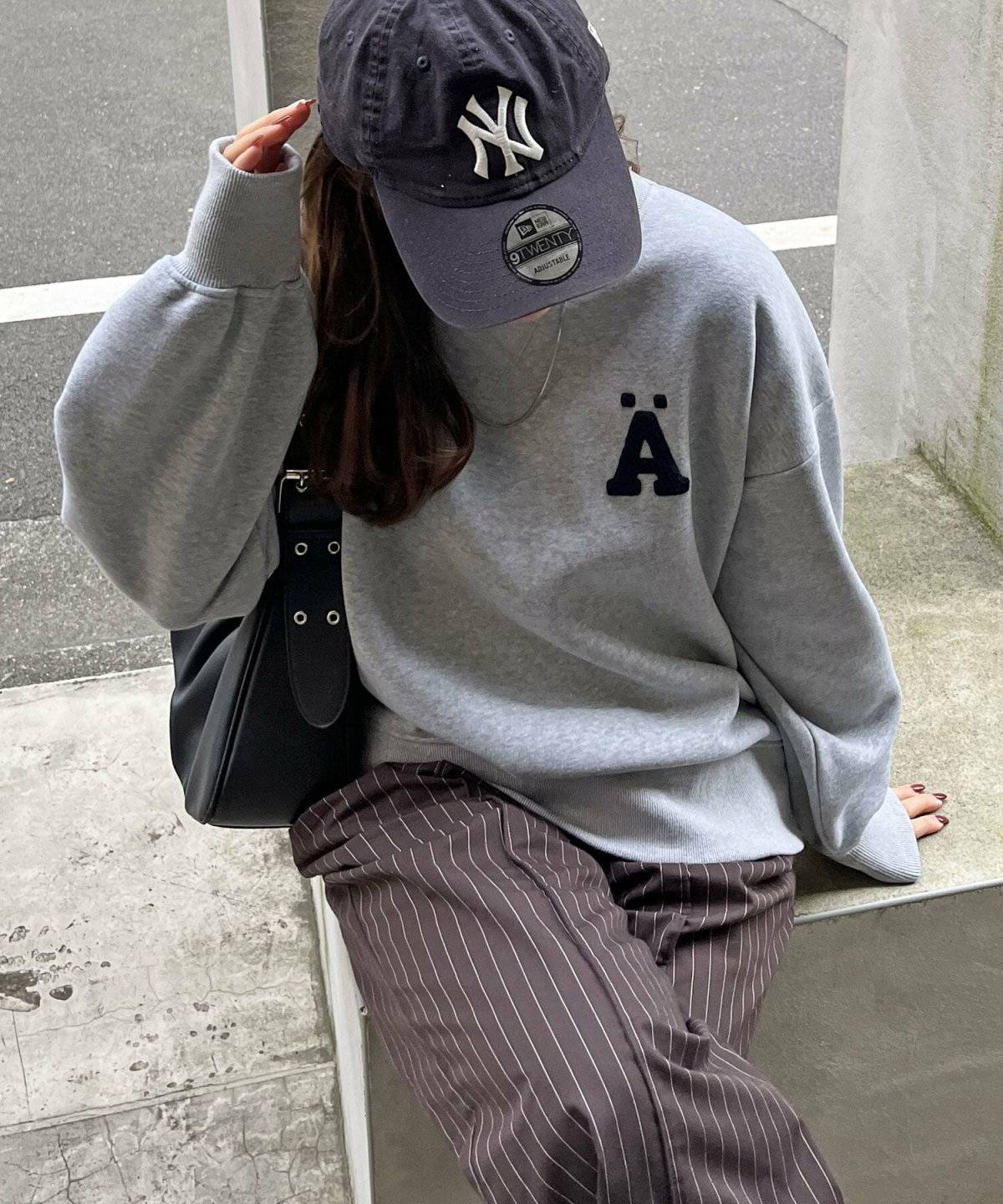 グレーのスウェットにブラウンのパンツを合わせた女性