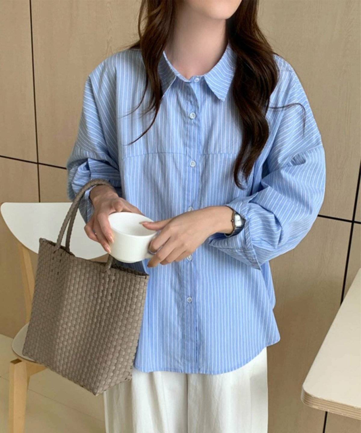 ストライプ柄のシャツに白パンツを合わせた女性