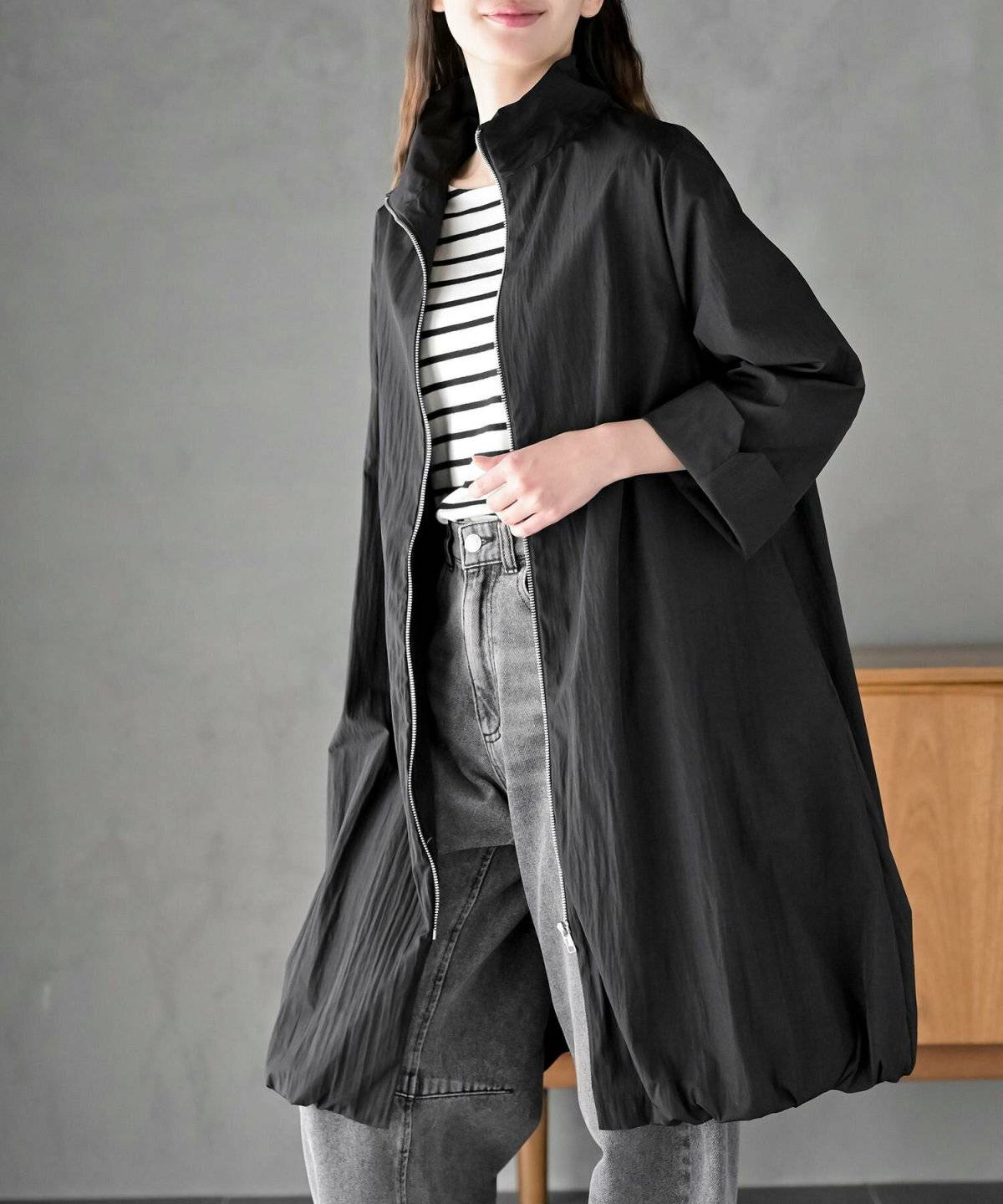 キャミソールにロングブルゾンを羽織ってデニムを合わせた女性