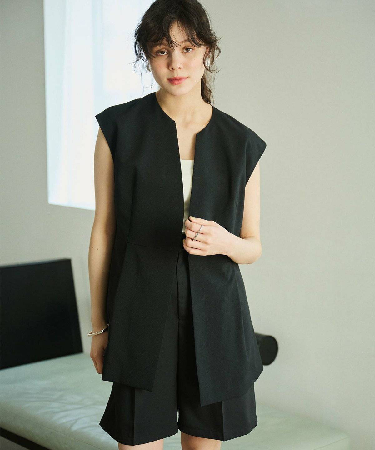 ベストとショートパンツのセットアップを着た女性