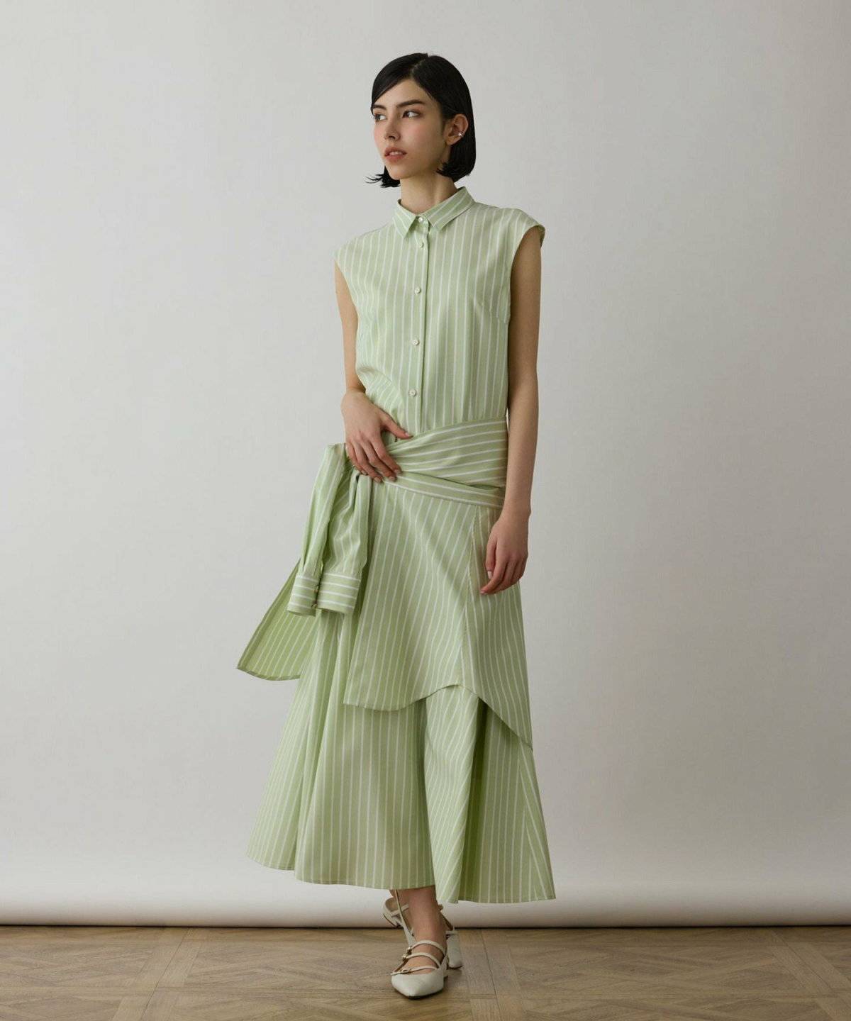 ミントグリーンのパンプスを履いた女性