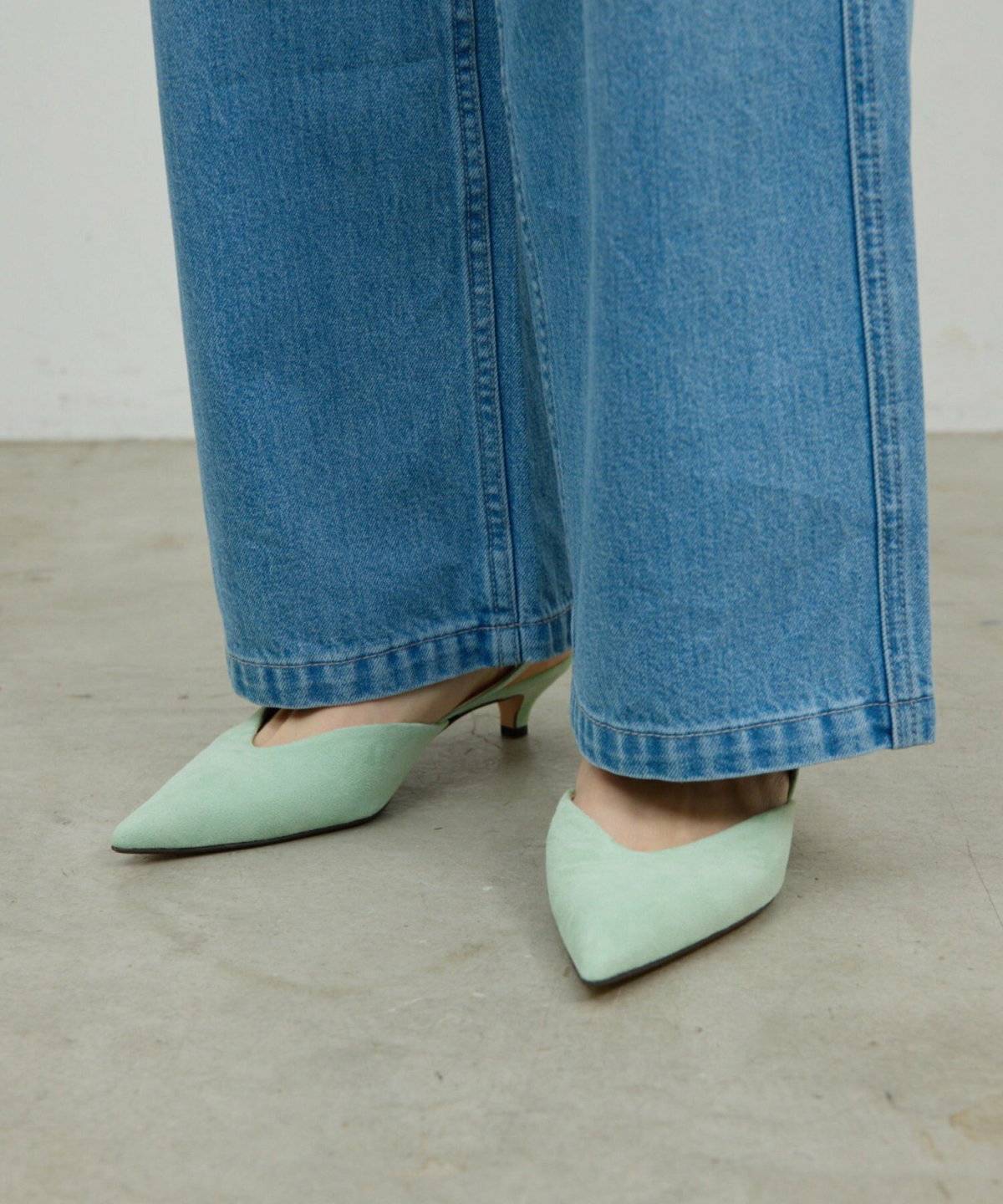ミントグリーンのパンプスを履いた女性