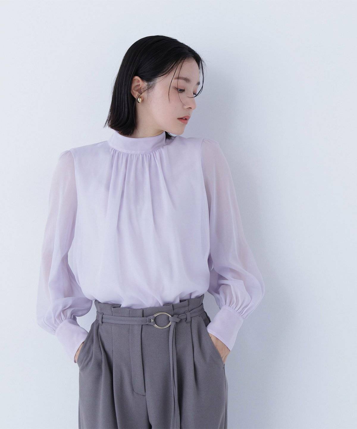 ミントグリーンのパンプスを履いた女性