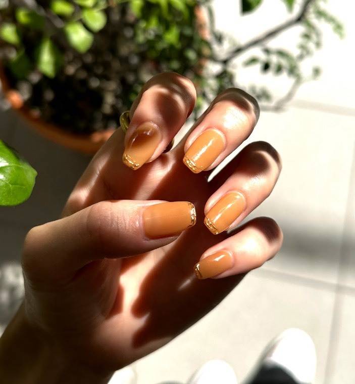 オレンジにゴールドラインを効かせたネイル