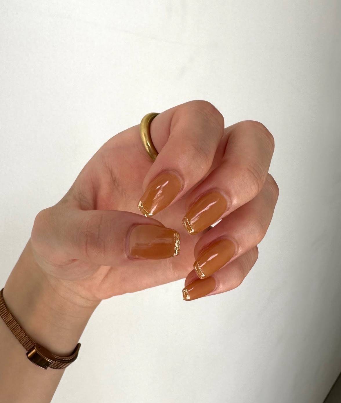 オレンジにゴールドラインを効かせたネイル