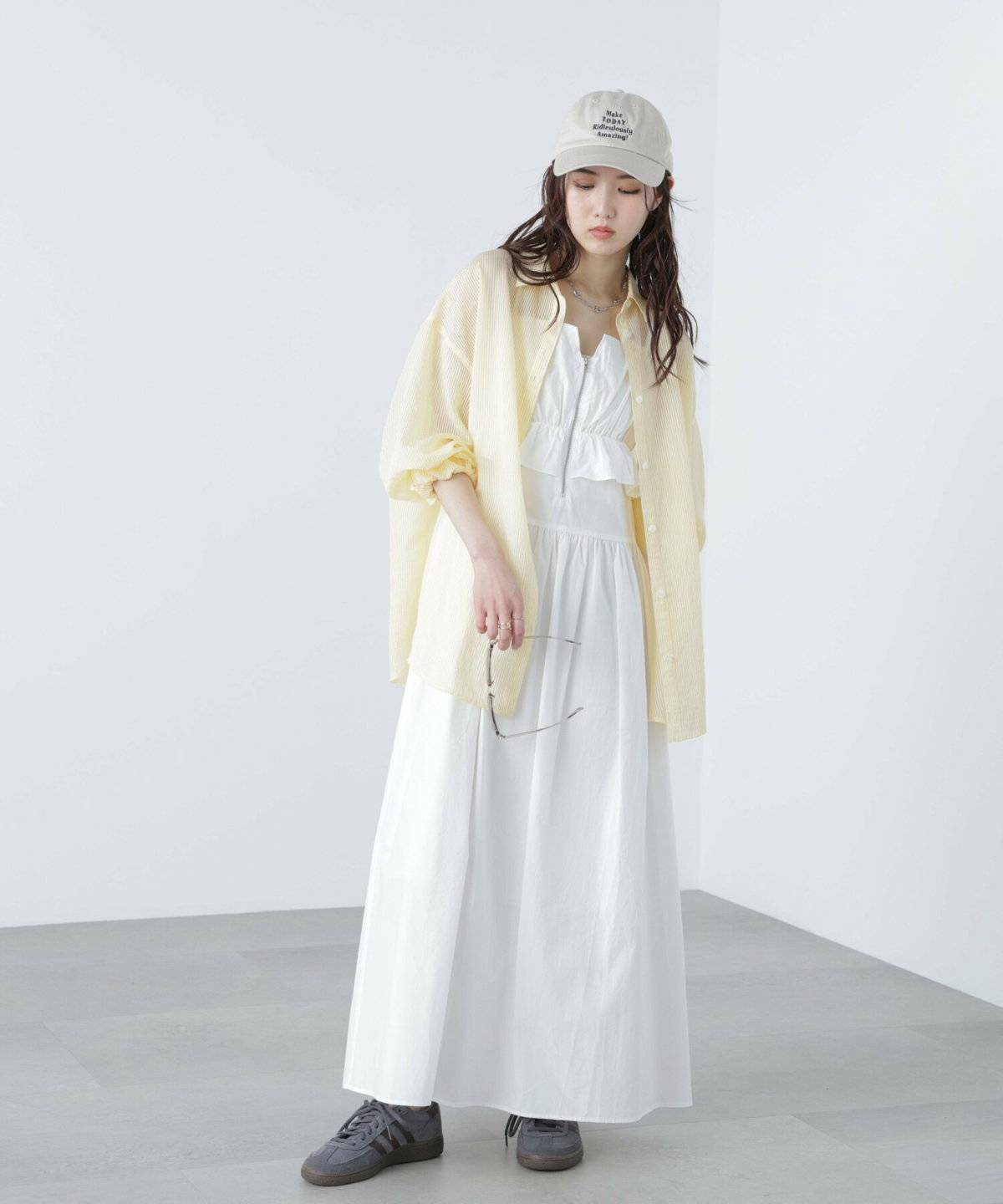 白ワンピースにブルーのカーディガンを羽織った女性