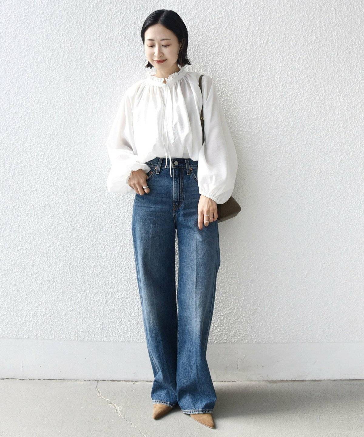 白ブラウスにデニムを合わせた女性