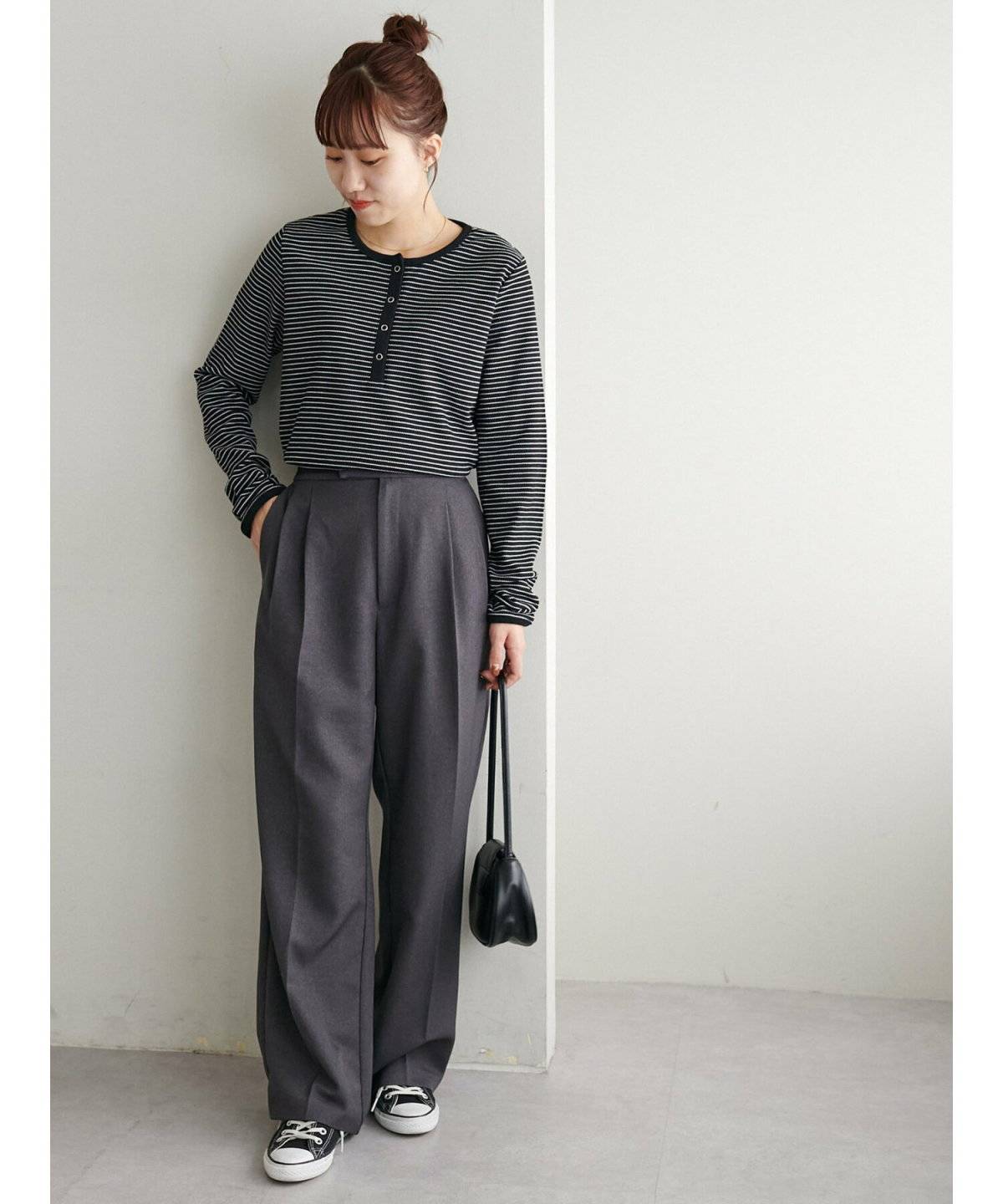 ボーダー柄トップスにグレーのパンツを合わせた女性