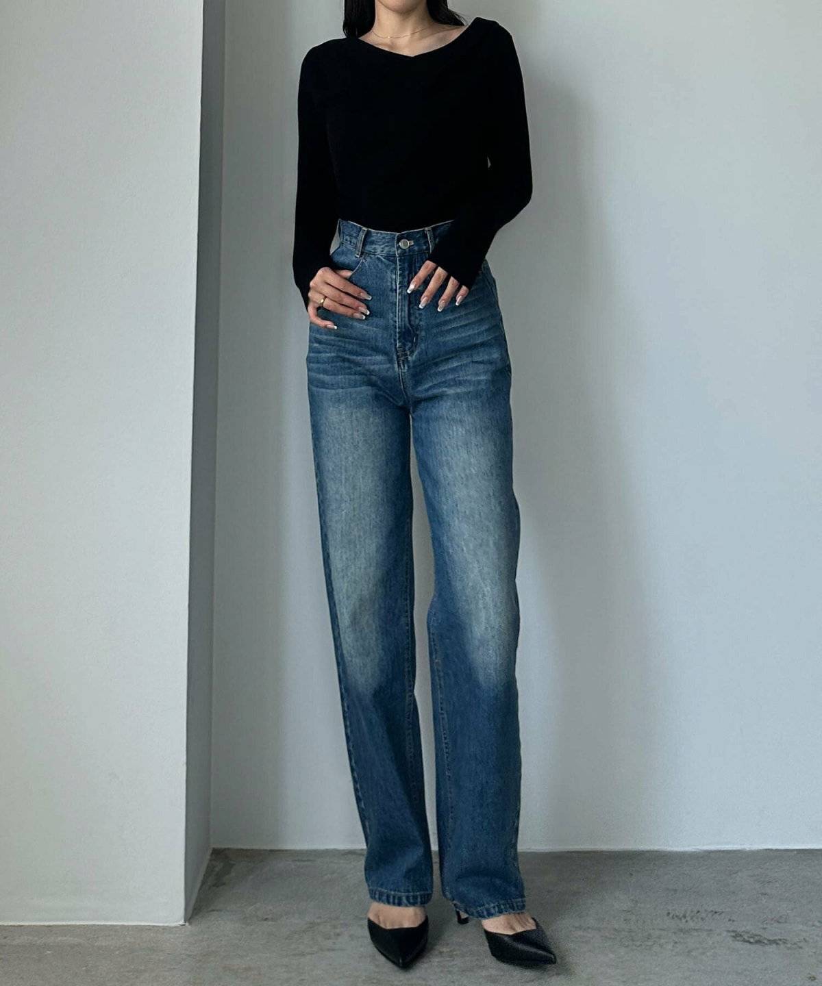 黒ニットにデニムを合わせた女性