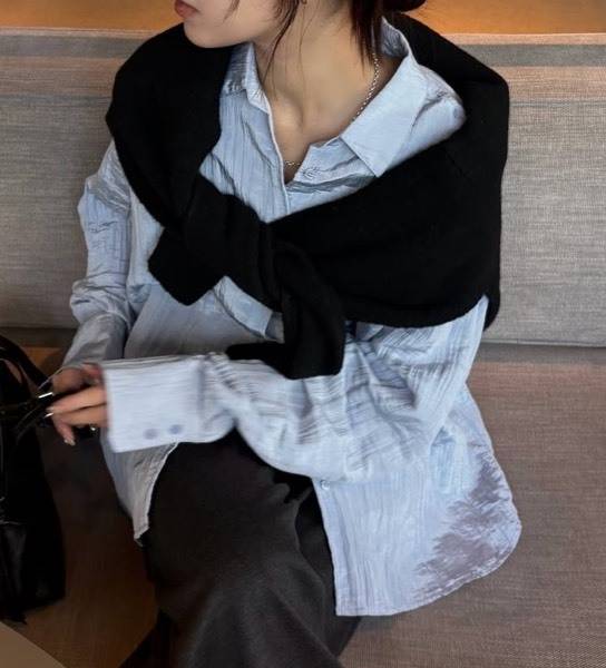 シャツにカーディガンを肩掛けしたコーディネート