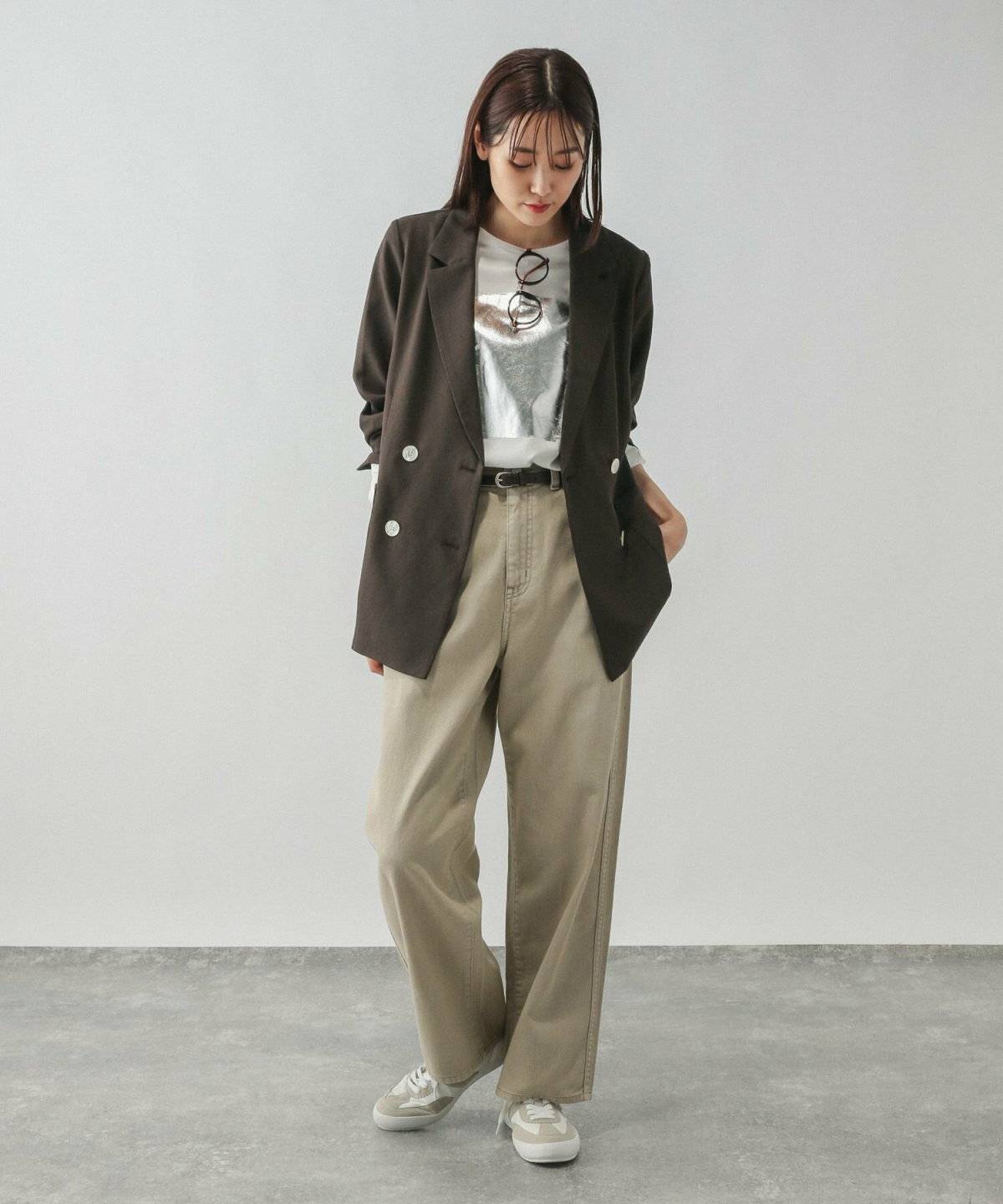 モノトーンコーデにベージュのジャケットを羽織った女性