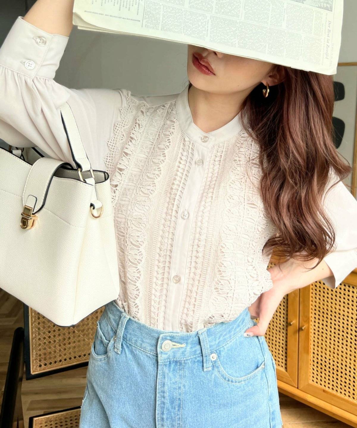 ベージュのブラウスにデニムを合わせた女性