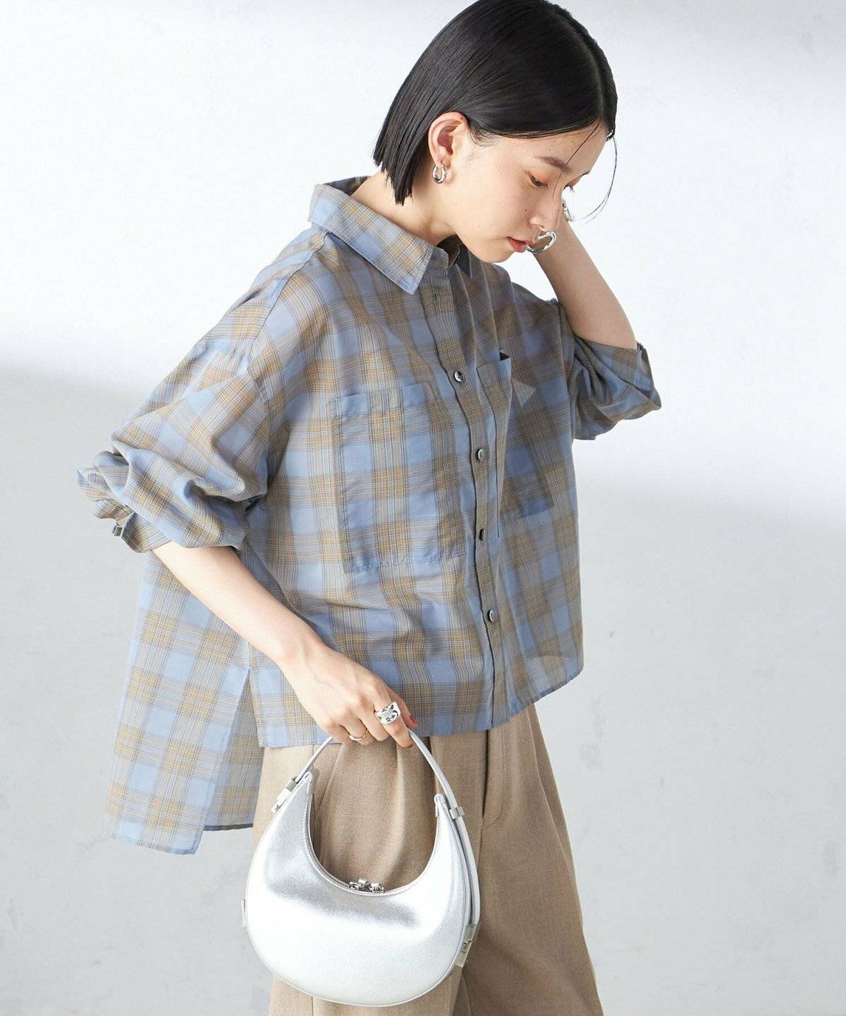 ネイビーのブラウスに白パンツを合わせた女性