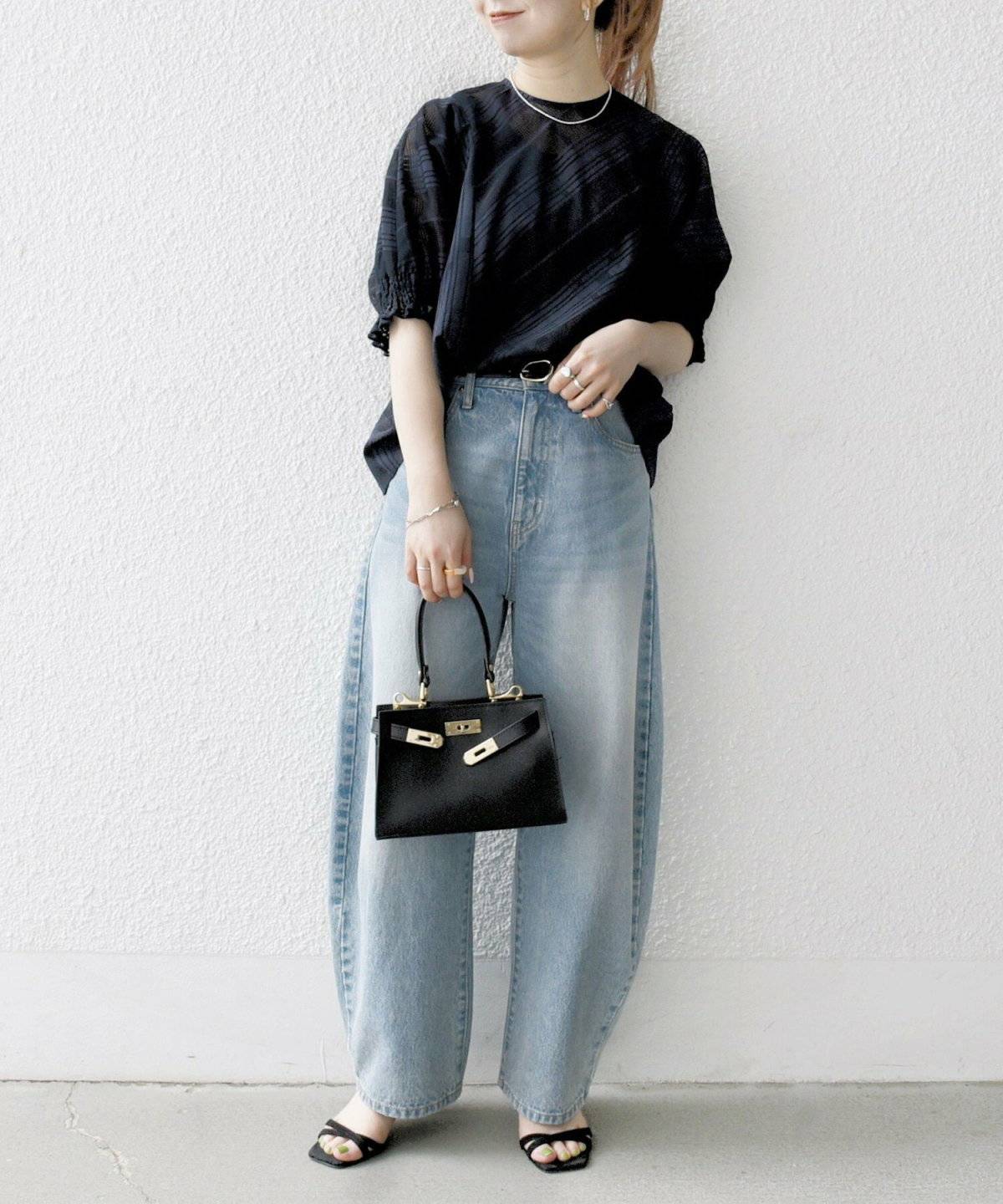 グレーのシャツにデニムを合わせた女性