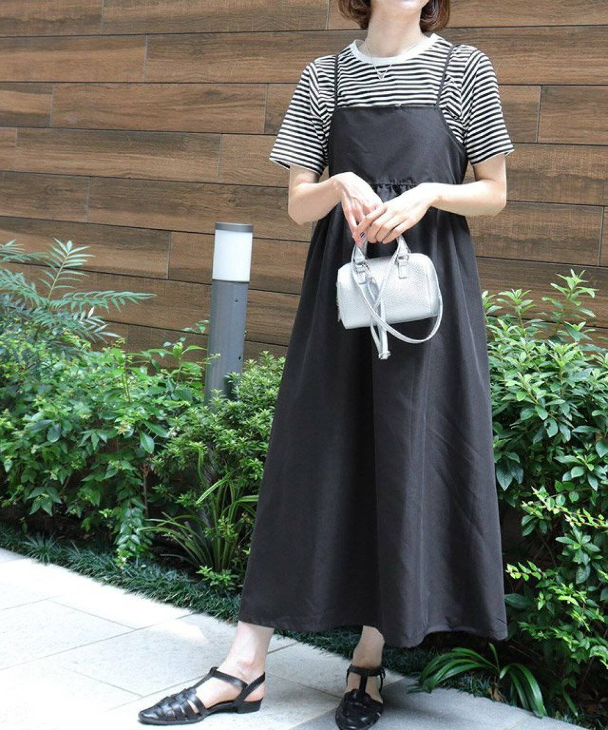 ボーダー柄Tシャツに黒ワンピースに重ねた女性