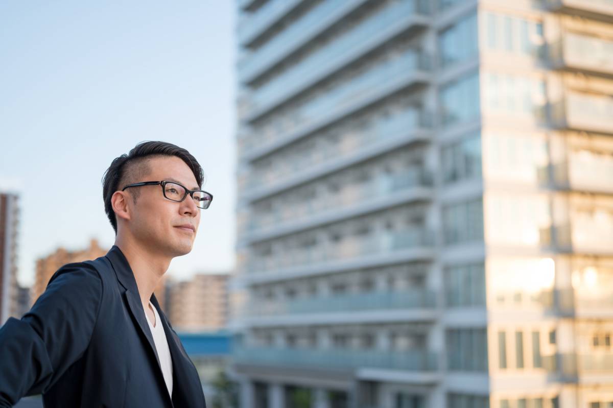 屋上でビルを見つめる男性