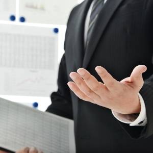  ホワイトボードの前でプレゼンする男性 