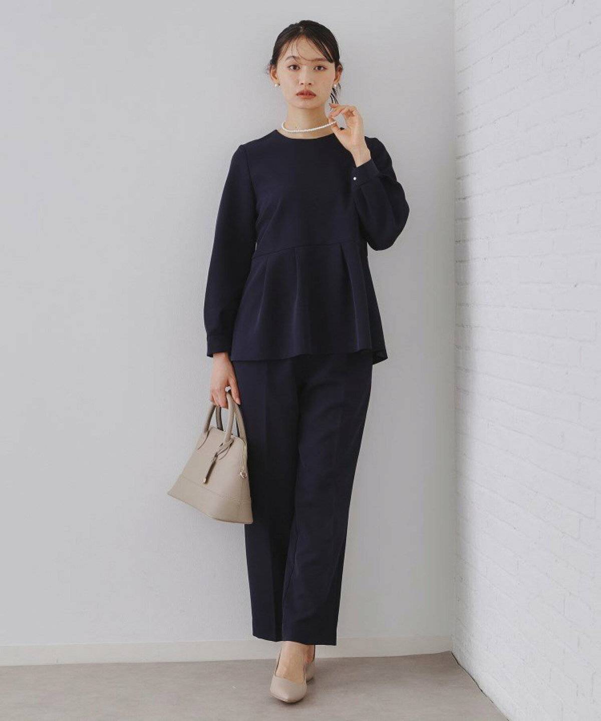 ネイビーのセットアップを着た女性