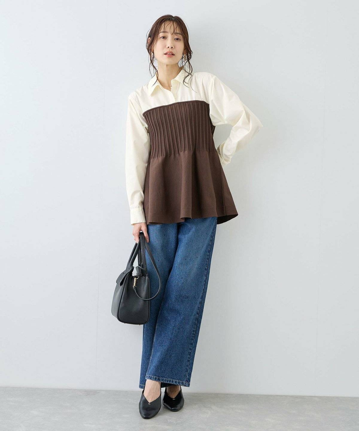 黒トップスにデニムを合わせた女性